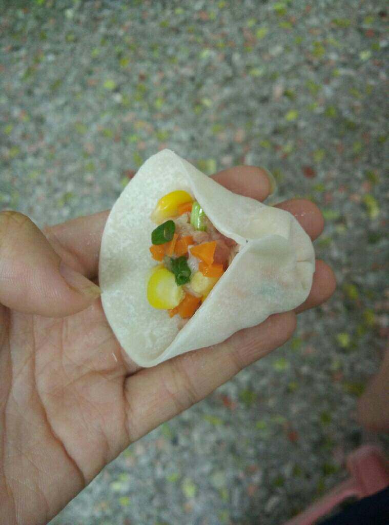 玉米猪肉饺子,将食指把边缘到的饺子皮按下去