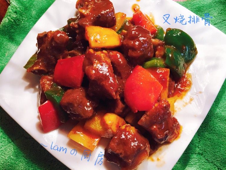 叉烧酱焖排骨,锅里下少许油，爆香排骨后，加适量的开水，大火煮开后转中火焖熟.放入少许<a style='color:red;display:inline-block;' href='/shicai/ 10588'>糖</a>和盐，倒入青红绿椒翻炒，挤入<a style='color:red;display:inline-block;' href='/shicai/ 699'>番茄酱</a>.炒匀装盘.