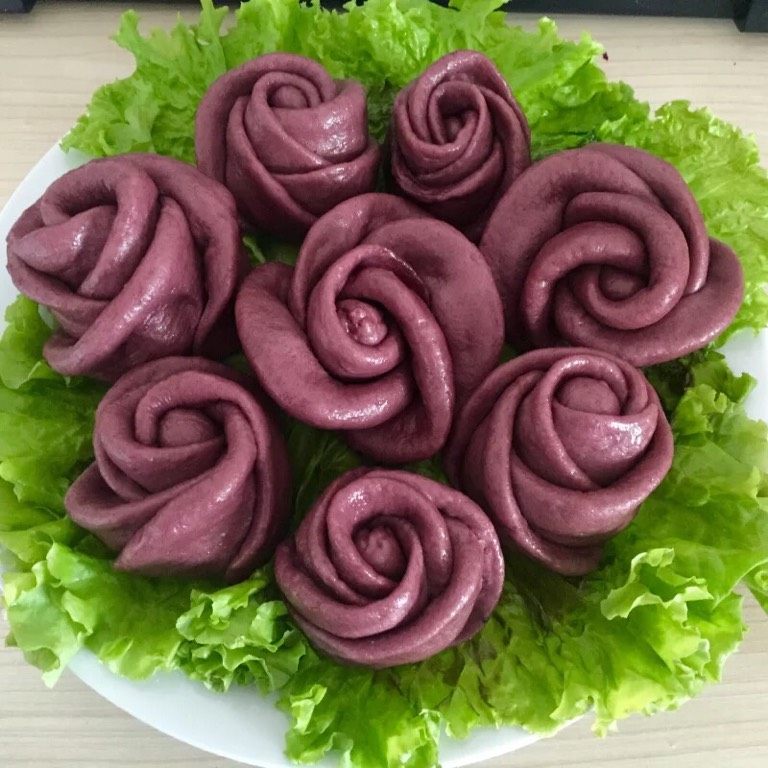 紫薯玫瑰花卷,如图冷水上锅,在玫瑰花上均匀的涂抹一层薄薄的食用油,蒸出来的玫瑰花光泽细腻,色彩艳丽,盖上盖子,开锅以后计时蒸15~20分钟,蒸好不要马上出锅,盖上盖子焖五分钟,装盘开吃。我们的玫瑰花可以是含苞待放,可以是含蕊吐香,也可以是肆意怒放,美丽的玫瑰花快来拥有他。