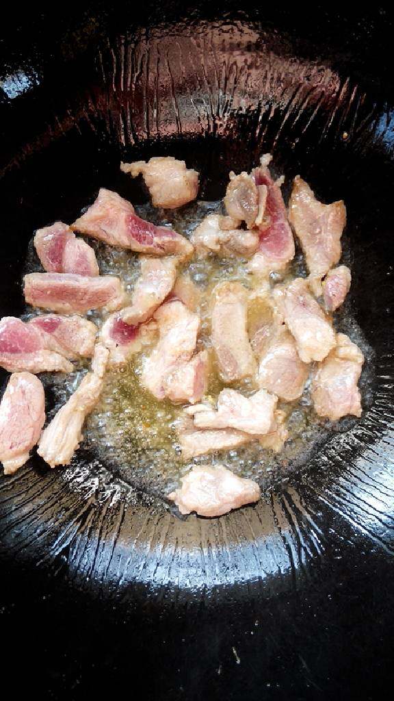 胡萝卜尖椒鸡蛋炒肉,锅内倒油,放入猪肉翻炒至微微变色。