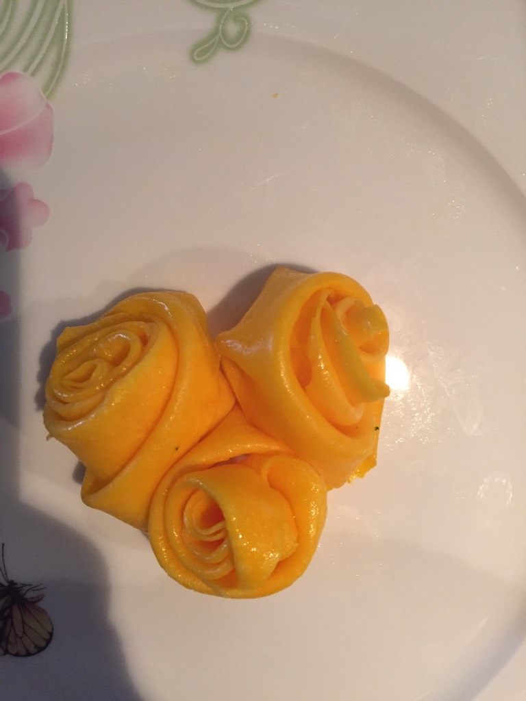 玫瑰鸡蛋饼,把蛋黄饼的边用小刀稍作修理,划成小长条,用一条的尽头开始转,转成三圈后往后折叠继续转成玫瑰花的形状装入碟中