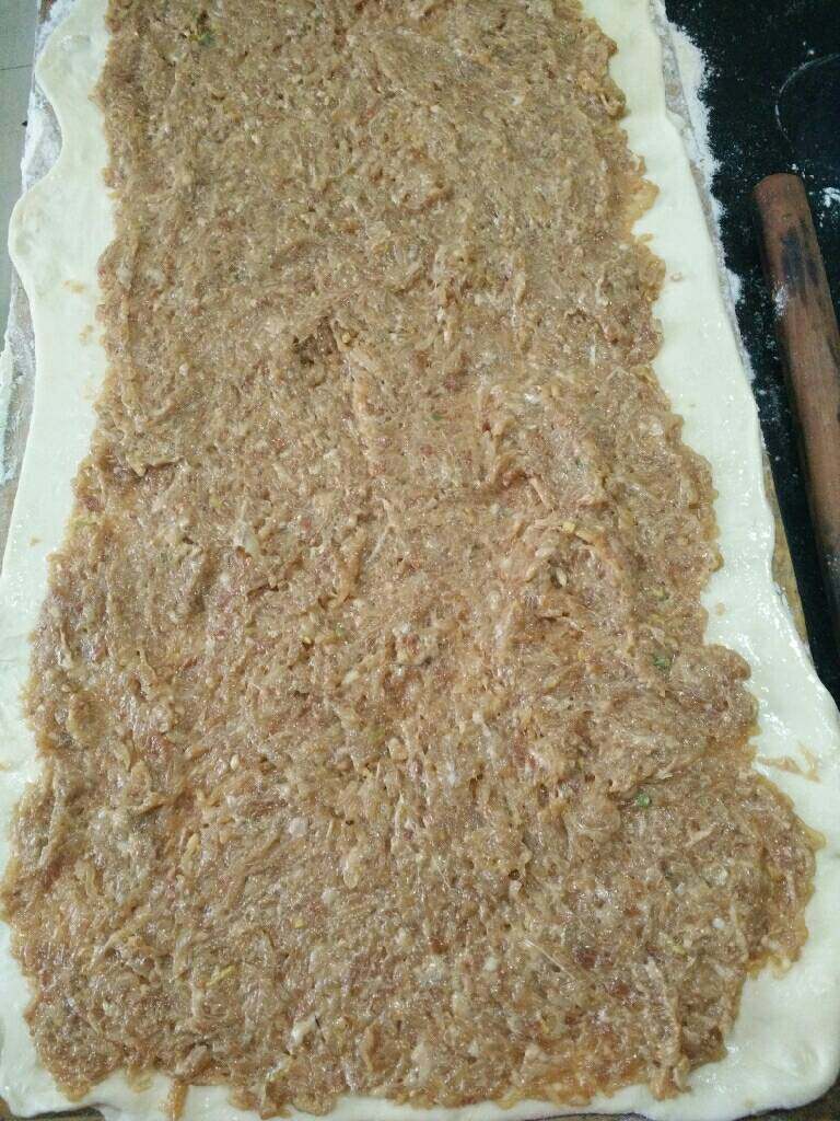 香酥猪肉萝卜饼,面团擀成约一厘米厚左右的面片，放上肉馅卷成长条