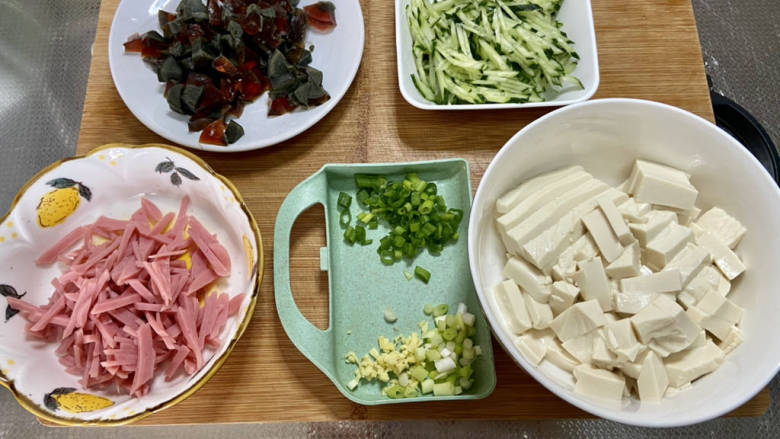皮蛋豆腐汤,改刀:嫩豆腐切小块,黄瓜火腿肠切丝,皮蛋切小块,小葱分葱白葱叶切末,姜切碎