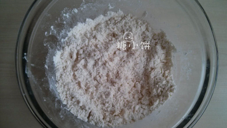 葡萄干司康,用手把黄油丁搓成小碎屑,搓几下放入粉堆中滚一滚。粘上粉后颗粒就容易搓开来了,不要搓太久以免手温把黄油融化了