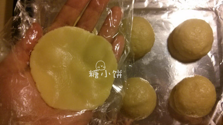 菠萝夹馅菠萝司康,取一份步骤11准备好的酥皮压成薄片,放在保鲜膜上压会比较方便取下来
