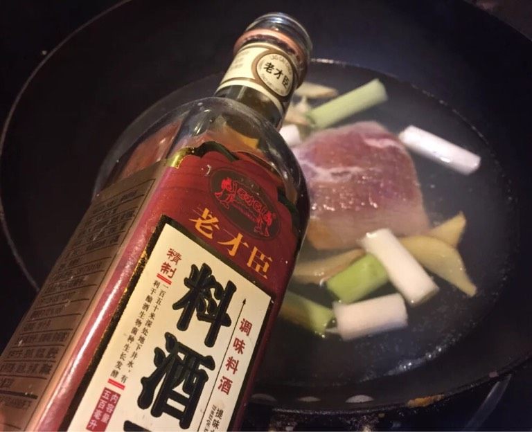 蒜泥白肉,如图锅中加入没过肉的清水,放入葱段,姜片,蒜瓣,<a style='color:red;display:inline-block;' href='/shicai/ 428'>五花肉</a>大火烧开,淋入料酒。