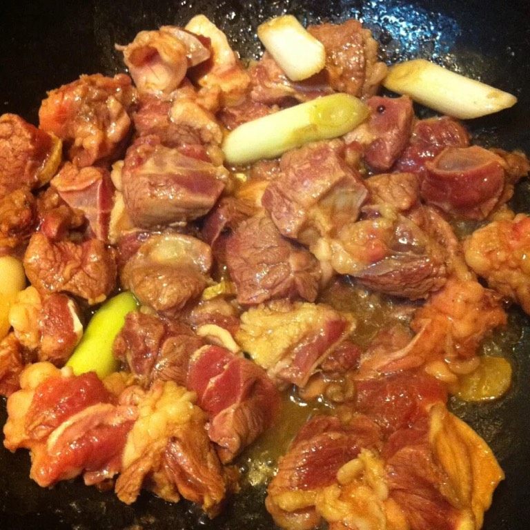 西红柿炖牛腩,热油,油热放入葱炒香,淋入酱油,加入牛腩翻炒至牛腩完全变色