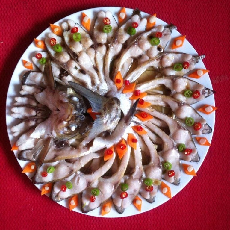 孔雀开屏鱼,如图芡汁:油锅热油,油热倒入蒸鱼豉油,葱段,姜片,花椒炒香,撒入适量盐。蒸好的鱼去掉鱼身的葱段,姜丝,淋入芡汁,小米椒青,红分前后摆在鱼身,胡萝卜摆在鱼身周边,香葱段摆在胡萝卜上