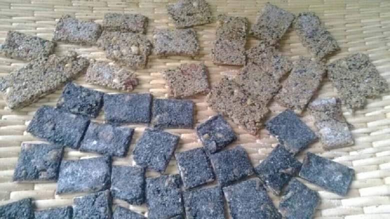 芝麻小酥饼,出锅后,放在桉板上,用擀面杖压成薄片,用刀分切成小块,待凉后,装入收纳盒里。