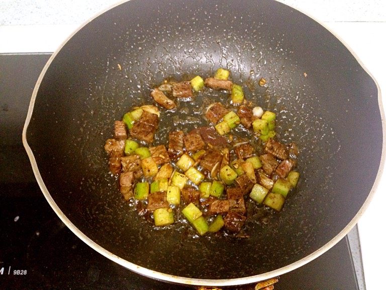 火龙果肥牛粒,往煎过牛肉的锅里倒入姜末蒜片爆香,收小火,再倒入青瓜粒翻炒一下,倒入肥牛粒,加一勺蚝油翻炒均匀。