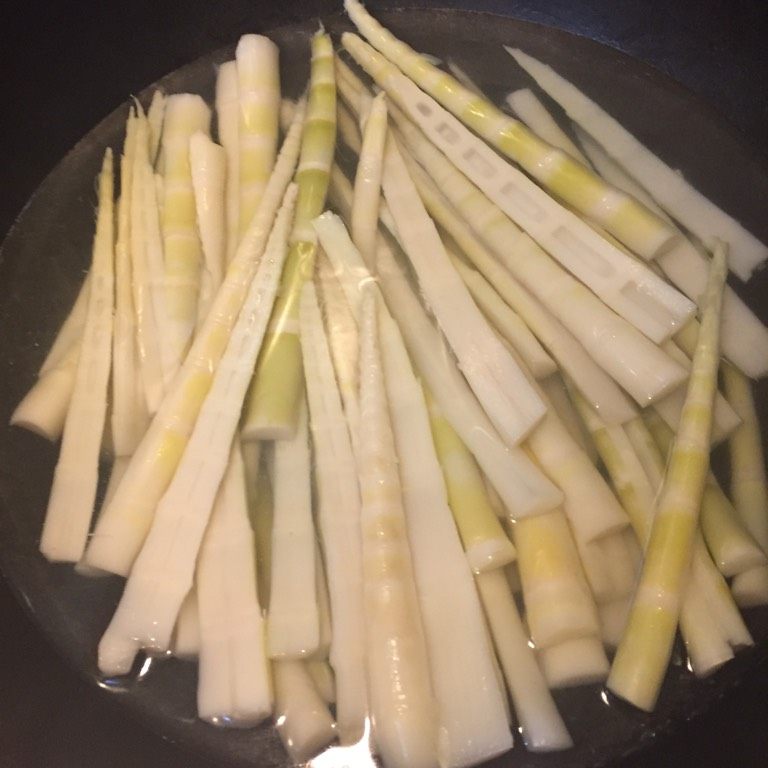 香辣竹笋,如图过热水焯一下,开锅煮一分钟即可,煮过的竹笋过凉水,这样口感更加脆爽