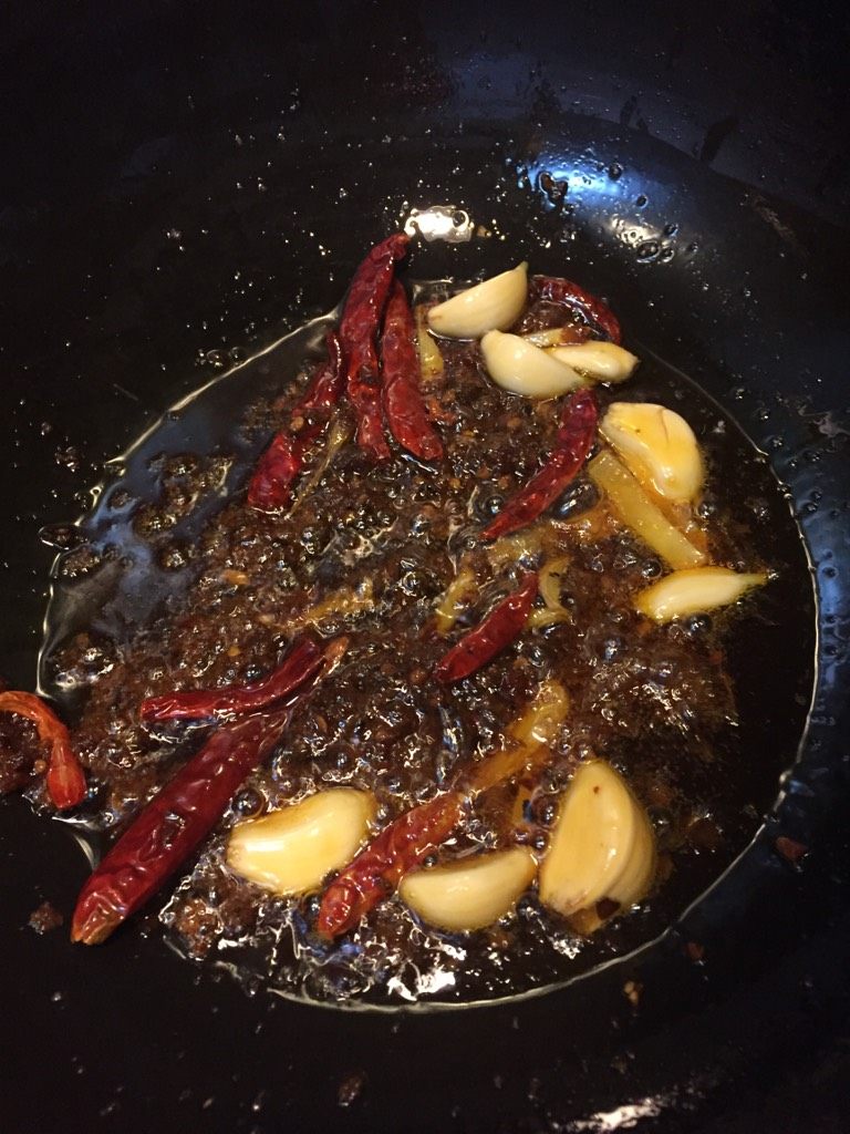 香辣竹笋,如图倒入辣椒,蒜瓣,<a style='color:red;display:inline-block;' href='/shicai/ 700'>花椒</a>,姜丝炒香(小火慢慢炒时间稍长更香哦)