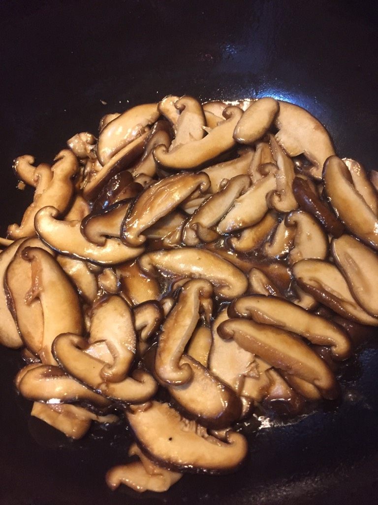 香菇扒鸡,如图锅中热油,油热倒入生抽,加入香菇炒香