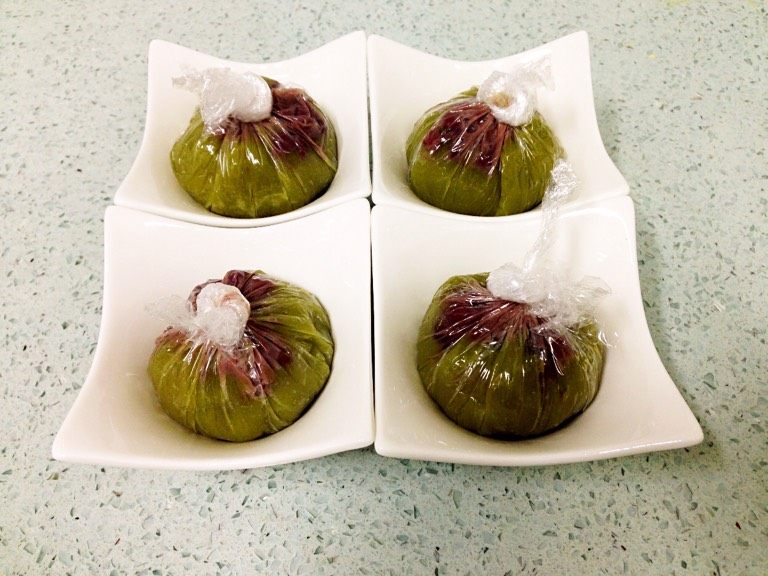 抹茶和菓子,稍晾凉,用保鲜膜把稠糊包起,在顶部加入粗粒红豆沙,扭转拧紧封口,自然放凉。