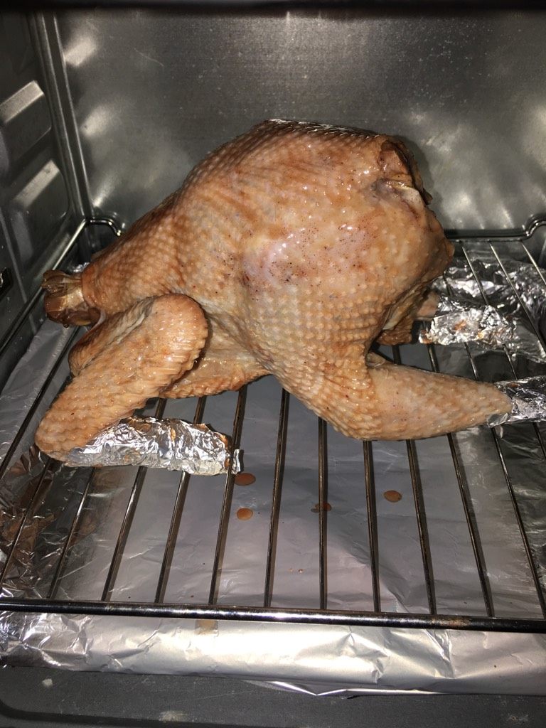 蜜汁烤鸡,如图就可以把鸡放进去烤了,烤盘用锡纸包起来,一会烤的时候用来接住烤鸡滴出来的油,以便好做卫生。大概20分钟拿出来刷一次蜂蜜,共刷三次。