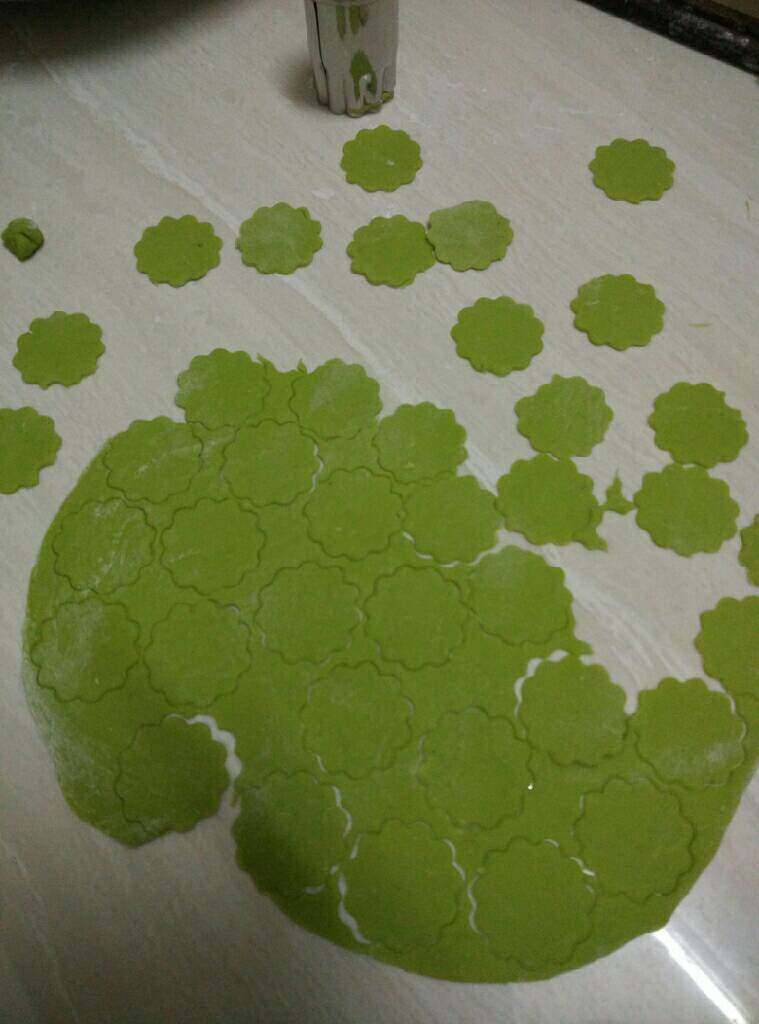 菠菜蝴蝶面,取出一小团面团,柔好用擀面杖擀成一片薄厚适中的饼皮,再用花纹模子印出一个个花纹