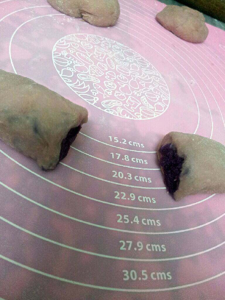 紫薯面包,用小刀切开一分为二,用擀面杖沾点水沾点白芝麻,转沾在紫薯中心,