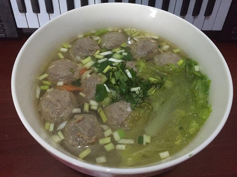 牛肉丸子汤,如图加入焯熟的胡萝卜和生菜,撒入香菜和剩余的葱花,美味快来品尝吧