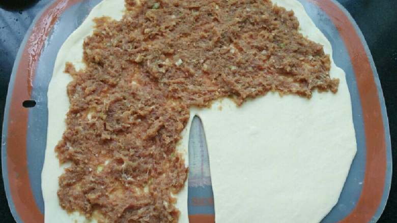 ≈家常肉饼≈,将肉馅按照图中所示的方式涂抹在面团上,留出1/4不涂抹肉馅。