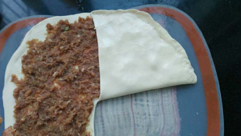 ≈家常肉饼≈,将面片从刀口的位置拎起,叠在肉馅上。把边捏死。