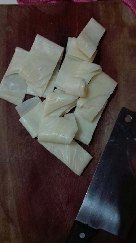 云南十八怪—牛奶做成片片卖,将买来的乳扇切成小条状，锅内烧油少量，油温不要太热。