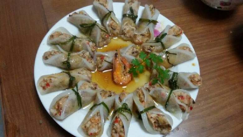 白玉鲜虾卷,白萝卜做片包上馅料，卷成卷，用葱条捆扎，装盘上蒸锅蒸7-8分钟后，取出热锅浇油勾芡即可。