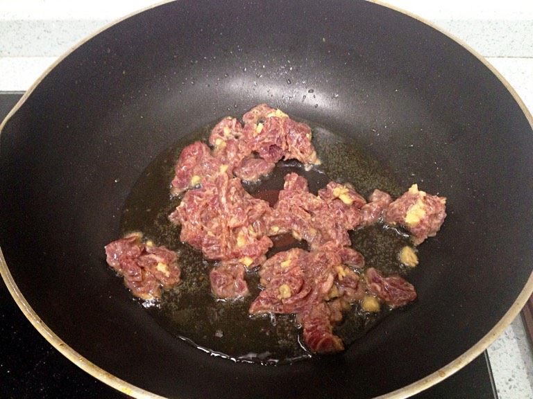 兰豆炒牛肉,热油锅,把牛肉爆炒至五成熟,盛出,锅里剩一点油。