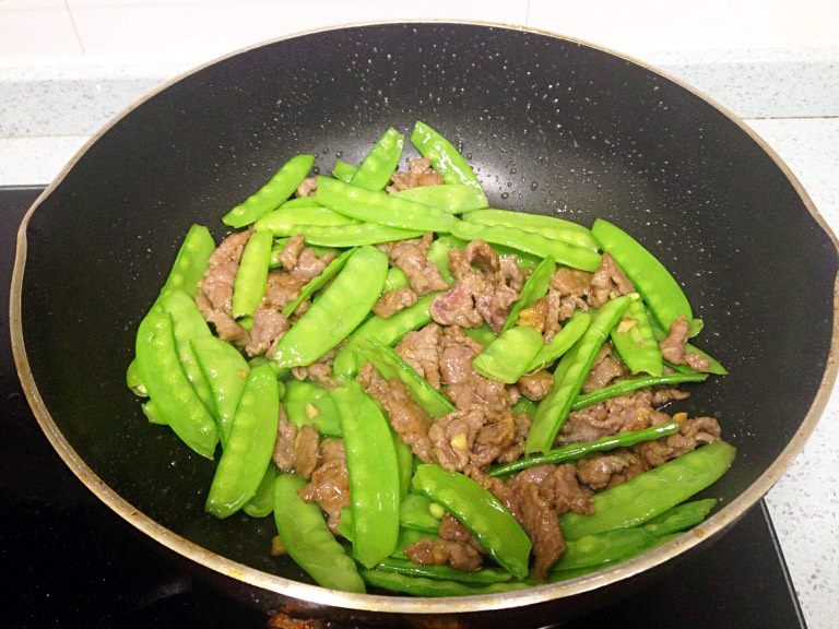 兰豆炒牛肉,倒入牛肉,小火翻炒拌匀,补半勺生抽增色增香。