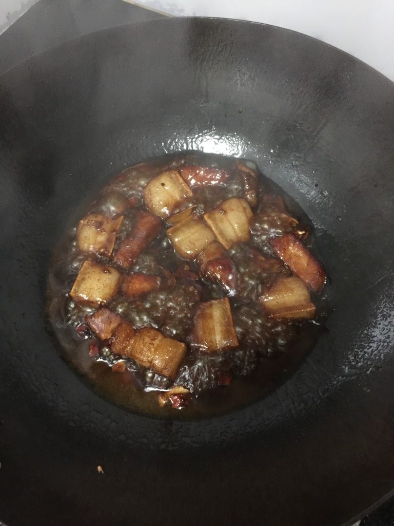 干豆角炖肉,热锅下油，油热后下肉块煎至出油且四面微黄，下姜片，红辣椒段和<a style='color:red;display:inline-block;' href='/shicai/ 695'>八角</a>一起煸香，加入料酒，酱油和一小勺糖，翻炒至肉完全上色