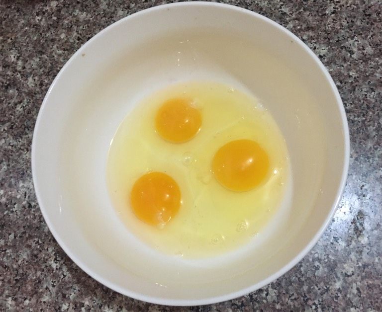 电饭煲蛋糕,如图鸡蛋打入容器中，手动打散加入第一次砂糖。