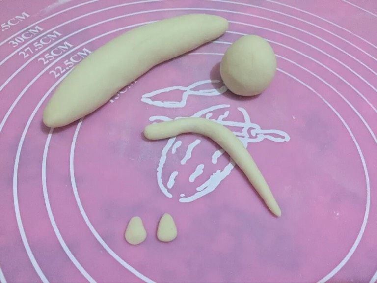 懒猫馒头,如图分成均匀的小面团,取一个小面团,一大块做懒猫的身体,一小块做懒猫的头,两小块做耳朵,一块做尾巴