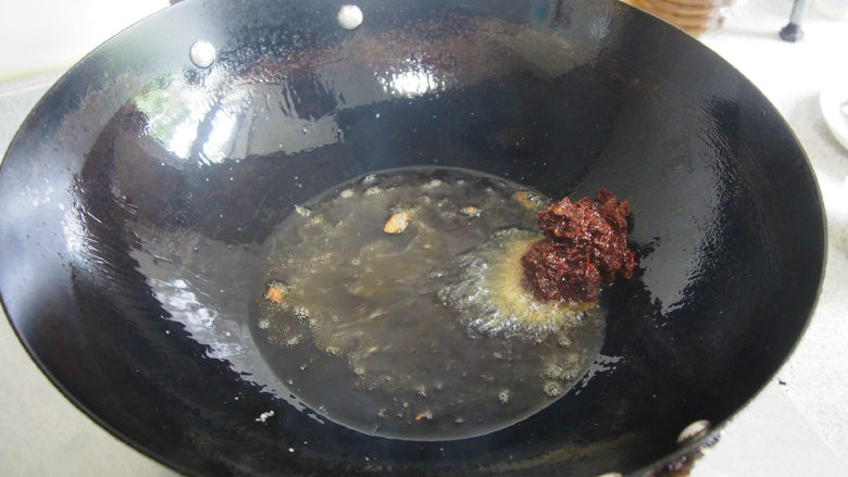 成都冒菜,再加入黑豆豉,以及姜蒜末和干辣椒,进行光速翻炒,此时香味四溢,记得打开抽油烟机