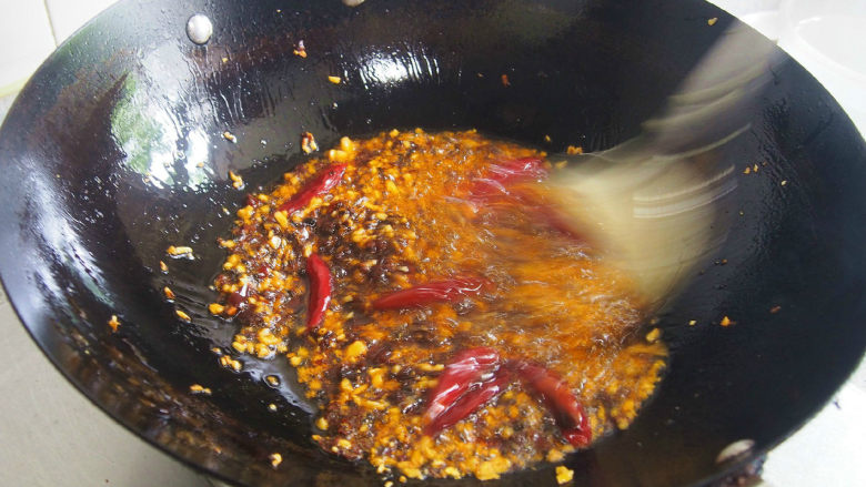成都冒菜,汤汁烧开后,倒入另一口汤锅里,用小火熬制十分钟的时间,然后把豆瓣豆豉辣椒等残渣打捞起来,免得一会儿渗入食物里。接下来就可以开始冒菜了。