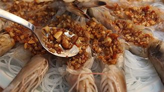 蒜蓉蒸大虾,将炒好的蒜蓉用小勺舀起,放在虾肉上面,最后用勺背稍微摁平;最后将剩的蒜蓉从盘中间倒入,然后上蒸锅,蒸15-20分钟即可。