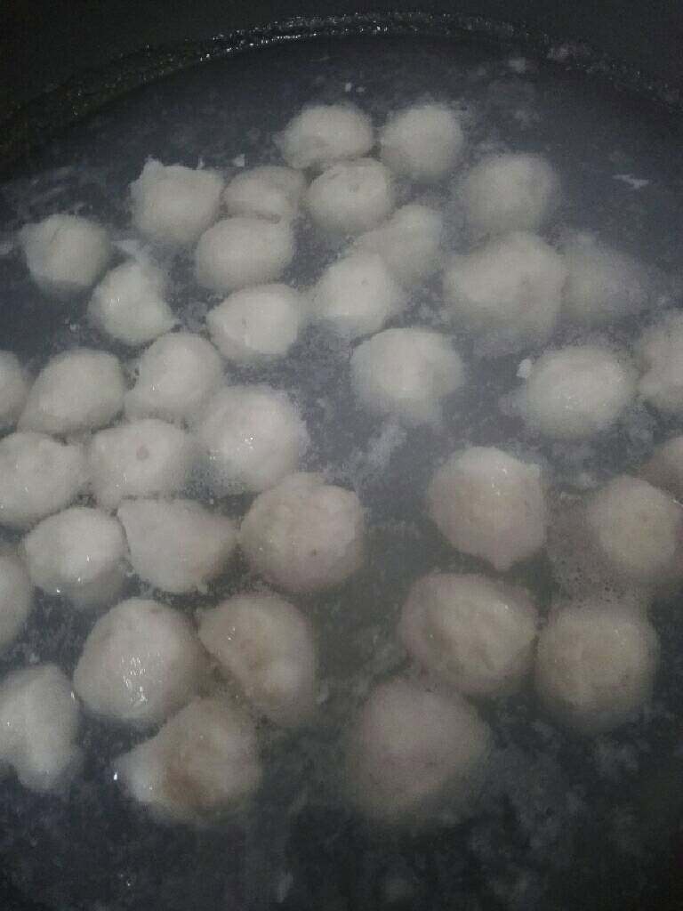 自制草鱼丸口蘑汤,锅中加入适量清水,开最小火,一定要最小火,一手抓起鱼肉,从虎口挤出鱼丸,另一手用勺子刮下(旁边放一碗清水,勺子需沾水,这样刮出丸子才光滑)。放入锅中,煮至鱼丸漂浮即可。