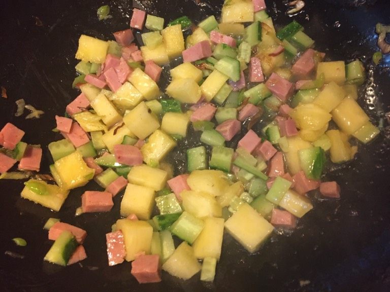 菠萝炒饭,如图锅留底油,放入火腿丁,黄瓜丁,菠萝丁翻炒