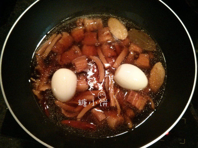 墨鱼干红烧肉,压好以后从高压锅中转入炒锅中,加入两只白煮蛋(剥壳后在表面划几刀入味);