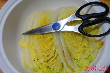 开水白菜,剪根:将焯过水的大白菜捞出,放入汤盆中,为了便于食用,剪去菜根。