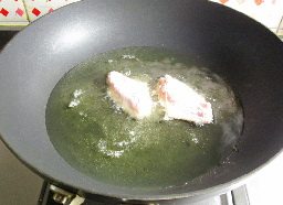 蛋黄鸡翅,锅中注入油,烧制6成热,逐个下入鸡翅。