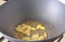 三杯啤酒鸭,锅中原油,下入姜片煸炒至颜色金黄;