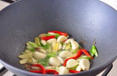 三杯啤酒鸭,再下入葱段、蒜粒和红辣椒,爆炒出香味儿;