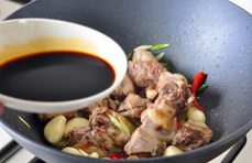 三杯啤酒鸭,加入酱油翻炒至鸭肉均匀上色;