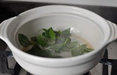 三杯啤酒鸭,待收汁将尽时,另一炉头烧热砂锅,关火并下入1大勺香油和几片九层塔叶;