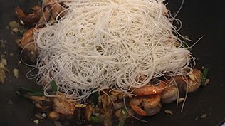 鲜虾金瓜米粉,转中小火,加入沥干水的米粉,用筷子搅拌均(如果太干可以加些温水进去)