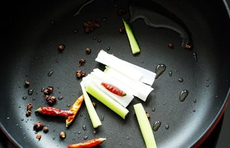 干煸鱿鱼,炒锅放入少许油,加入花椒、麻椒,小火加热出香气再放入<a style='color:red;display:inline-block;' href='/shicai/ 86474'>干辣椒</a>和葱段,大火加热翻炒出香气。