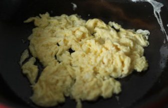 虾仁什锦炒饭,用勺子快速将鸡蛋搅散，盛出；