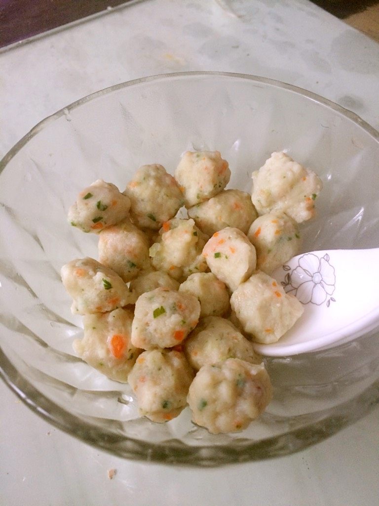 七彩咖喱鱼丸,清水烧开，在似开未开时用手抓鱼肉，将鱼肉从虎口处挤出在勺子上放入锅中，鱼丸即成