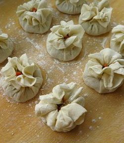 “都一处”烧卖,收拢起包入馅料的面皮,在半腰处捏褶子,中间留一小口露出馅料,上面的面皮外翻呈梅花状。