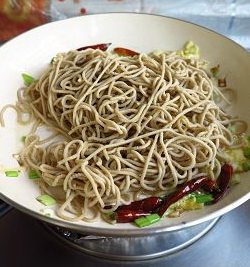 麻油炒莜面,放入蒸熟的莜面条,大火翻炒几下。