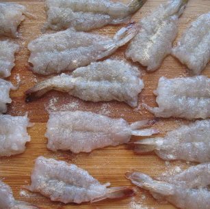 韩式煎虾饼,重新清洗虾肉。然后把它们一个一个的平铺在案板上,洒上适量盐和胡椒粉腌制15分钟。